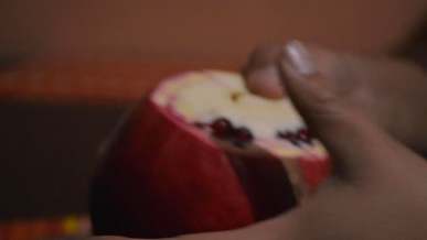 breaking open a pomegranate fruit
