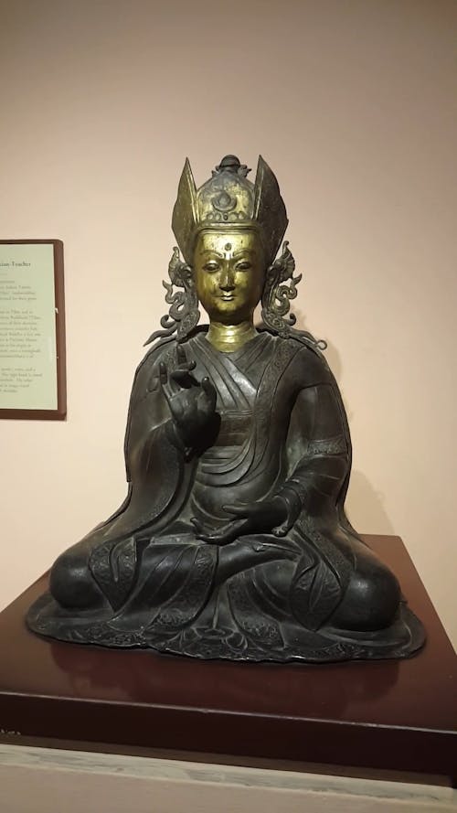 A Brass Buddha Statue In Display