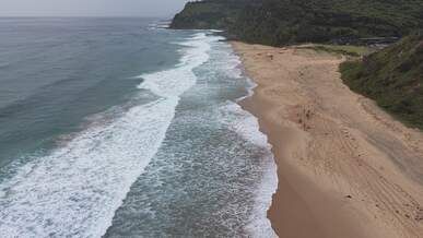 aerial view of pristine beach waves at dawn