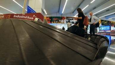 travelers waiting for their baggage to pass through the conveyor machine