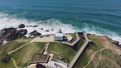 aerial view of coastal lighthouse and ocean waves