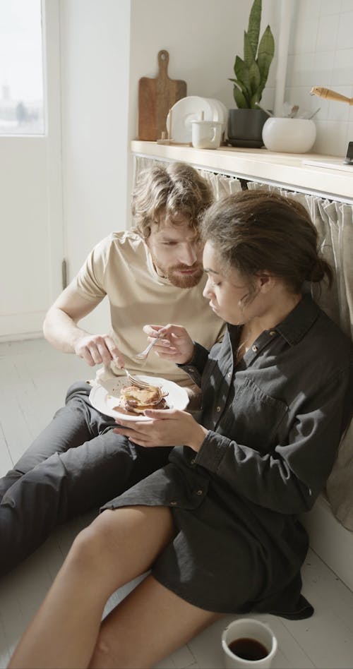 Ein Paar, Das Frühstück Teilt, Während Es Auf Dem Boden Sitzt
