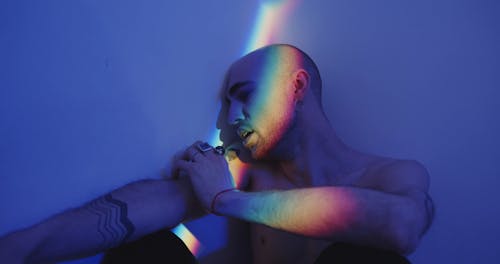 A Man In Emotional Grief Seated On The Corner Of A Wall