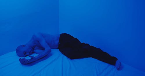 A Man Cuddling Himself In Bed