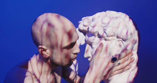 Man Kissing A Head Bust