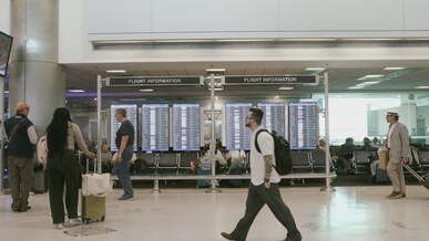 busy airport terminal with travelers and flight info