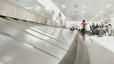 busy airport baggage claim area with travelers