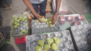 street vendor organizing fresh pears on display