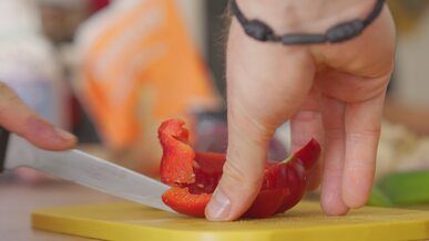 slicing colorful bell peppers in home kitchen