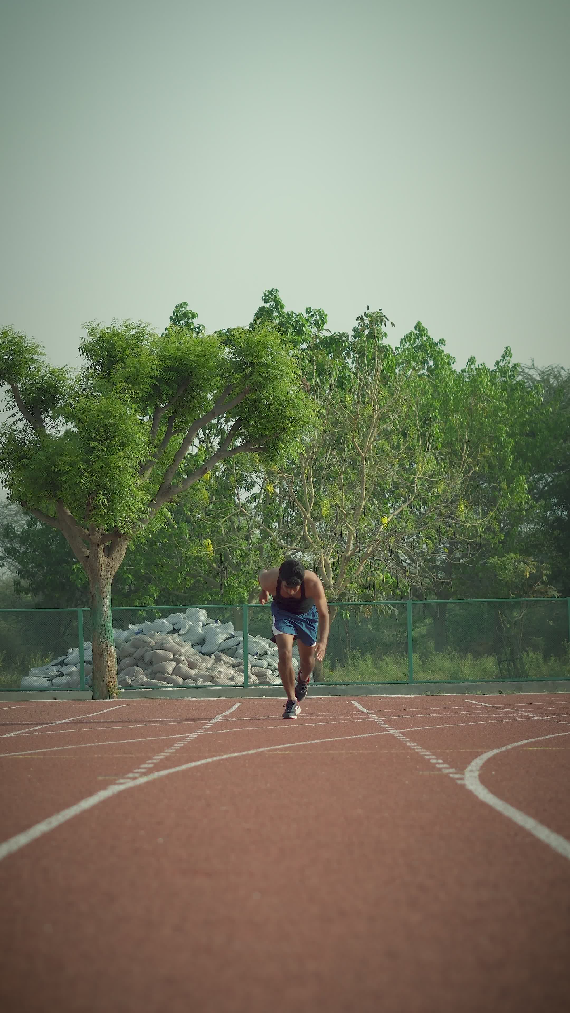 athlete sprinting on outdoor track 37264421