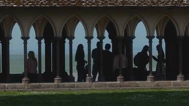 silhouetted figures in gothic cloister
