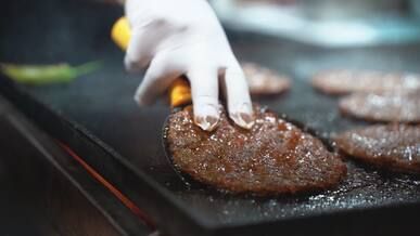 close up of burgers cooking on a griddle