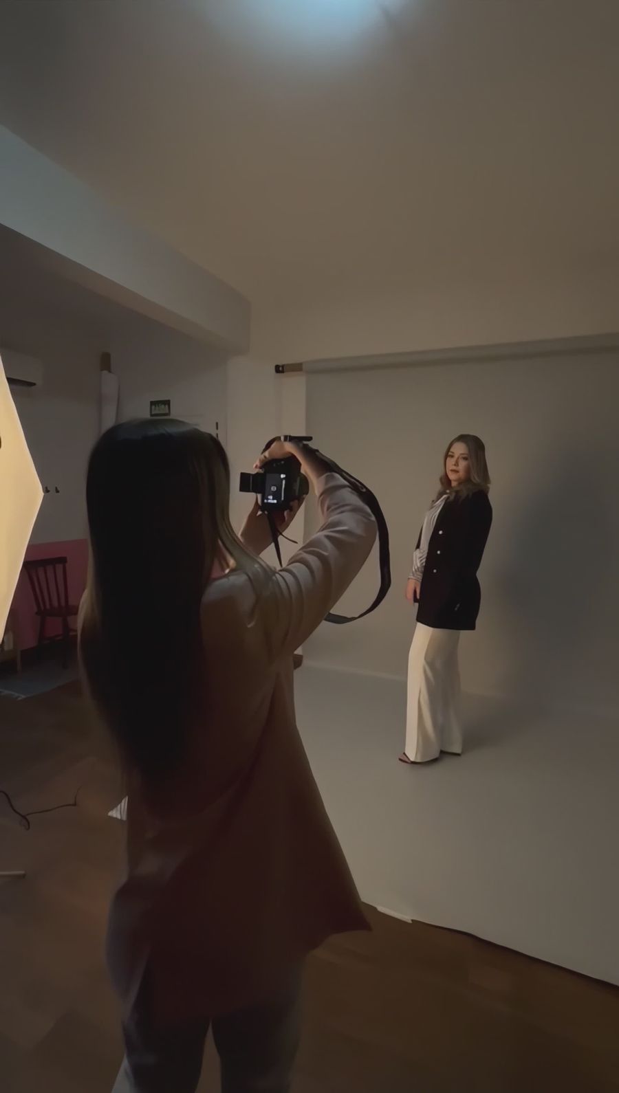 A photographer captures a model in a professional indoor studio setup