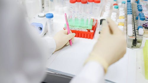 A Medical Practitioner Taking Notes of a Specimen