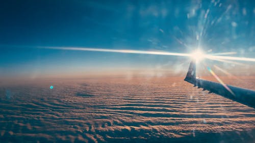 An Airplane Flying Over A Desert Land 