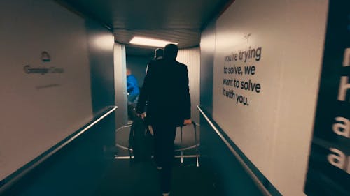 Back View of People Walking in the Aerobridge