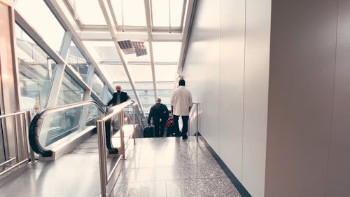 People Using the Escalator and Stairs on an Airport