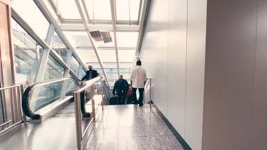 people using the escalator and stairs on an airport