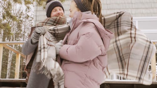 A Couple In Full Winter Clothes Hugging Outside In A Cold Weather