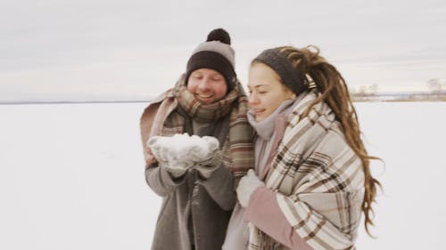 Beelden Van Het Paar Dat Samen De Sneeuw Blaast