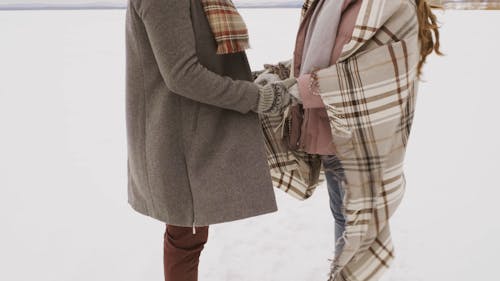 Кадры пары, держащей руки в снежном поле