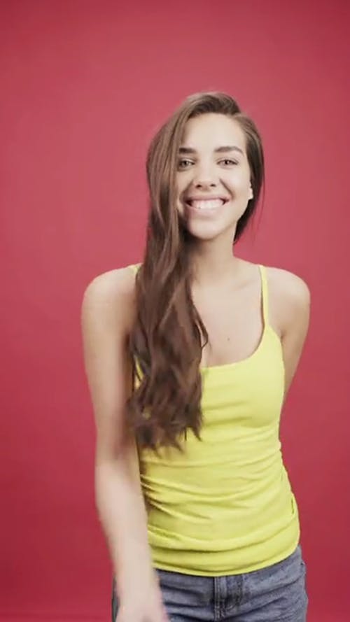 Een Jonge Vrouw In Gele Top Confetti Boven Het Hoofd Gooien
