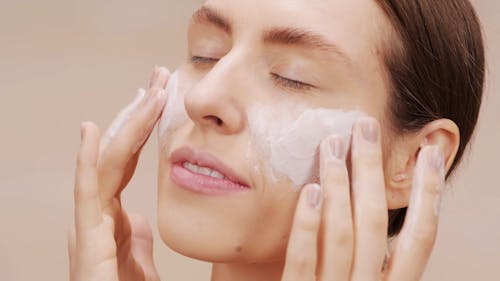 Close-up Footage of a Woman Applying Moisturizer on Her Face