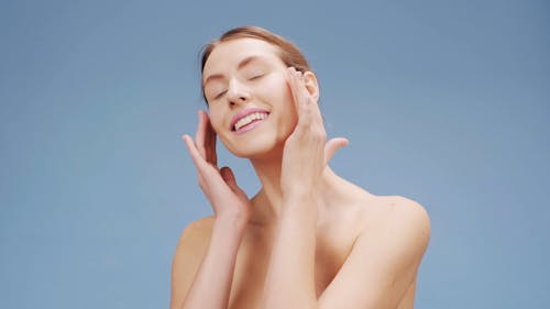 A Woman Massaging Her Face With Her Fingers