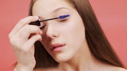 Woman Applying Purple Mascara