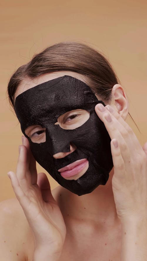 A Woman Removing A Charcoal Face Mask