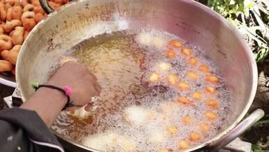 street vendor frying indian desserts outdoors