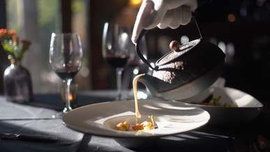 person pouring sauce on food