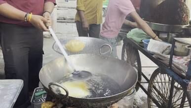 street food vendor frying bread at outdoor market