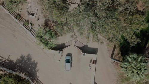 A Car Entering The Gates Of A Property Onward To Its Driveway