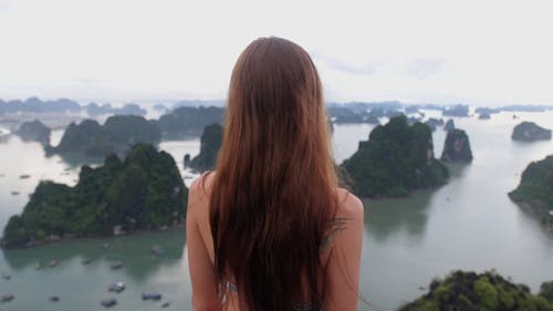A Woman Standing On A Mountain Top Enjoying The Group Of Islands View 
