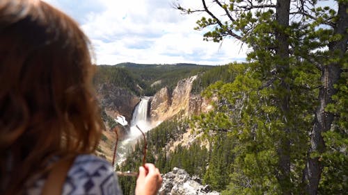 Une Femme Profitant De La Vue Sur Les Chutes D'eau Du Sommet De La Montagne