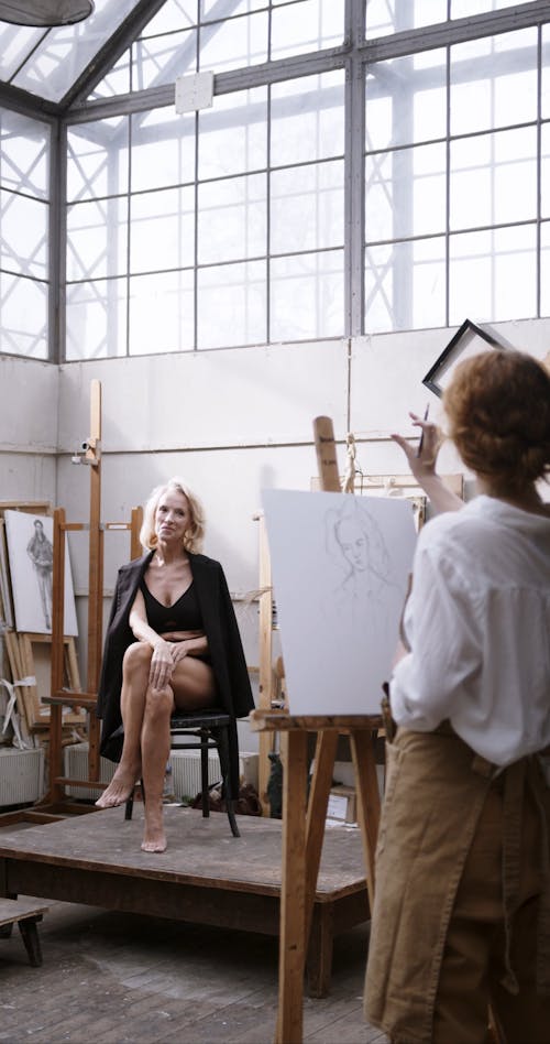 A Woman Having Her Canvass Painting Done By An Artist