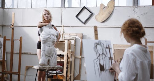 Um Artista Está Pintando Uma Mulher Atrás De Uma Escultura