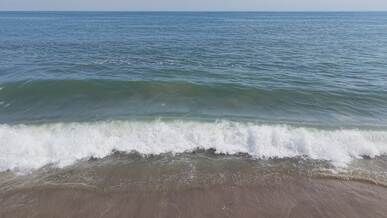 serene ocean waves hitting sandy shoreline