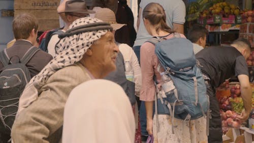 An Elderly Man Standing in front of a Fruit Stand