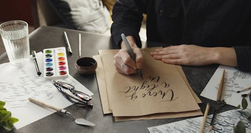 Person Writing On A Brown Paper