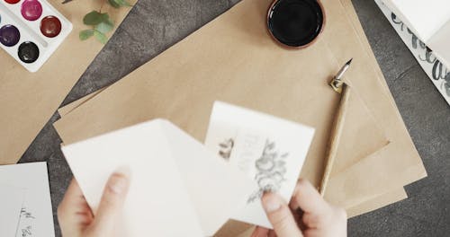 Enclosing A Handmade Card In An Envelope Before Marking It With A Heart Symbol