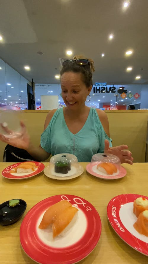 A Woman Playing with Plates of Food in a Restaurant