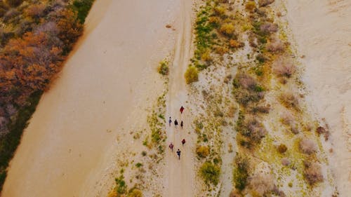 Un Grupo De Personas Caminando Por Una Tierra Desértica