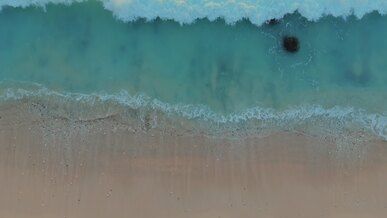 aerial view of gentle ocean waves on sandy beach
