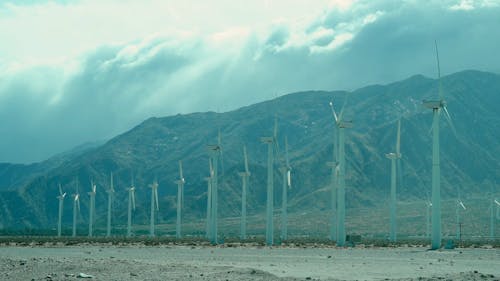 Full Shot of Wind Turbines near a Mountainside