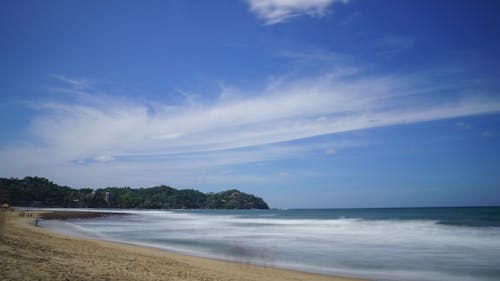 People Walking By The Beach Shore