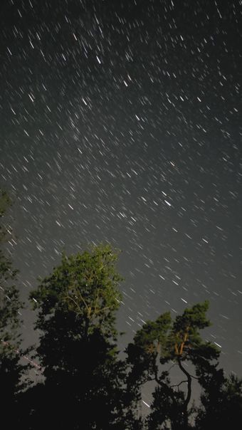 星轨延长，同时一颗人造卫星划过天际视频素材