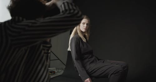 A Woman Model Spinning In Poses With A Stool Chair During The Photo Shoot