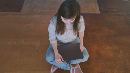 Woman Sitting On The Floor Using A Laptop